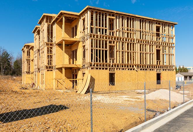 a close-up of temporary chain link fences enclosing a job site, signaling progress in the project's development in Harrisville